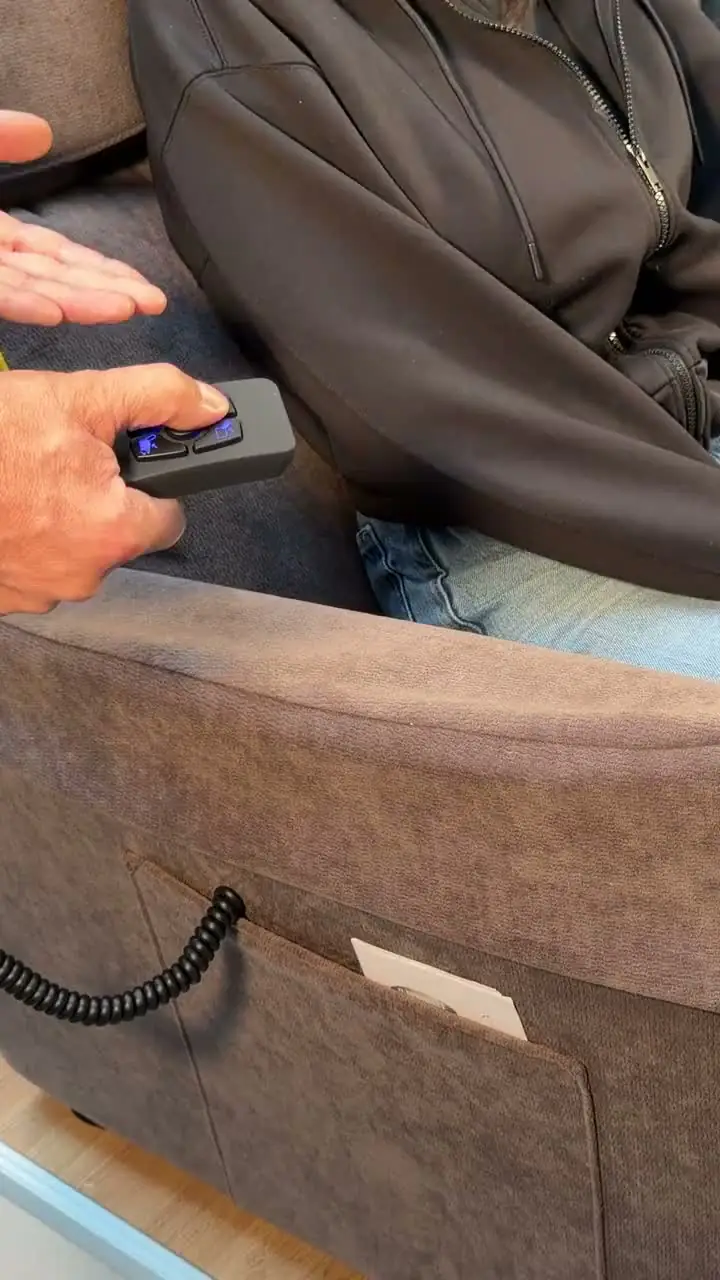 Il telecomando di una poltrona alzapersona accanto al bracciolo, nello store Cocoon